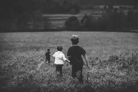 little kids running in field